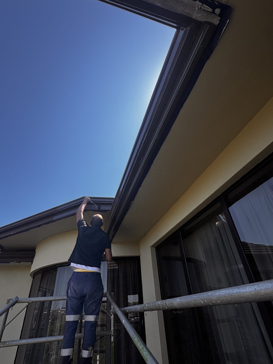Painter brushing a fascia on a Perth home
